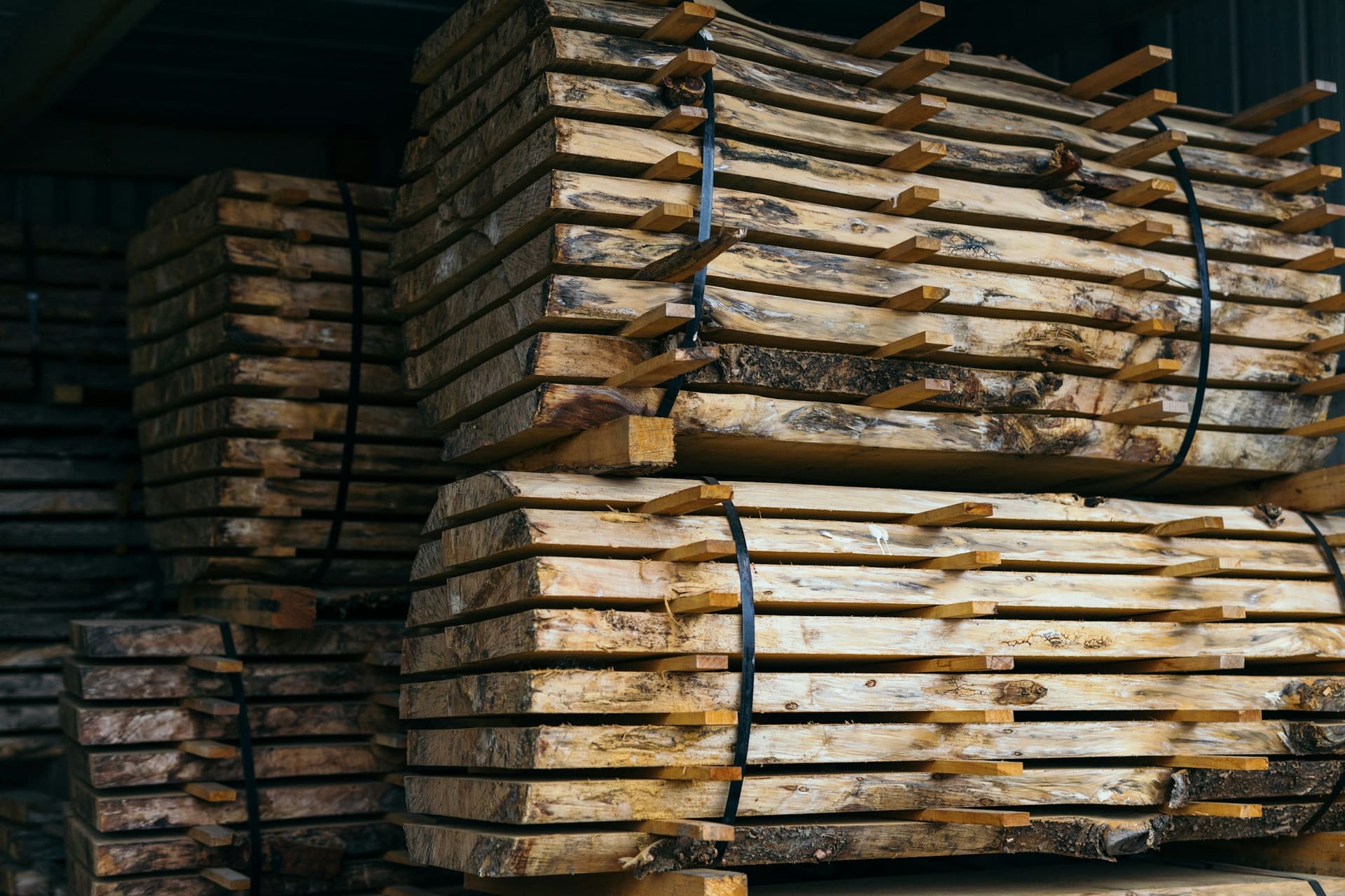 Stacked timber in covered storage, used as contact page context imagery.