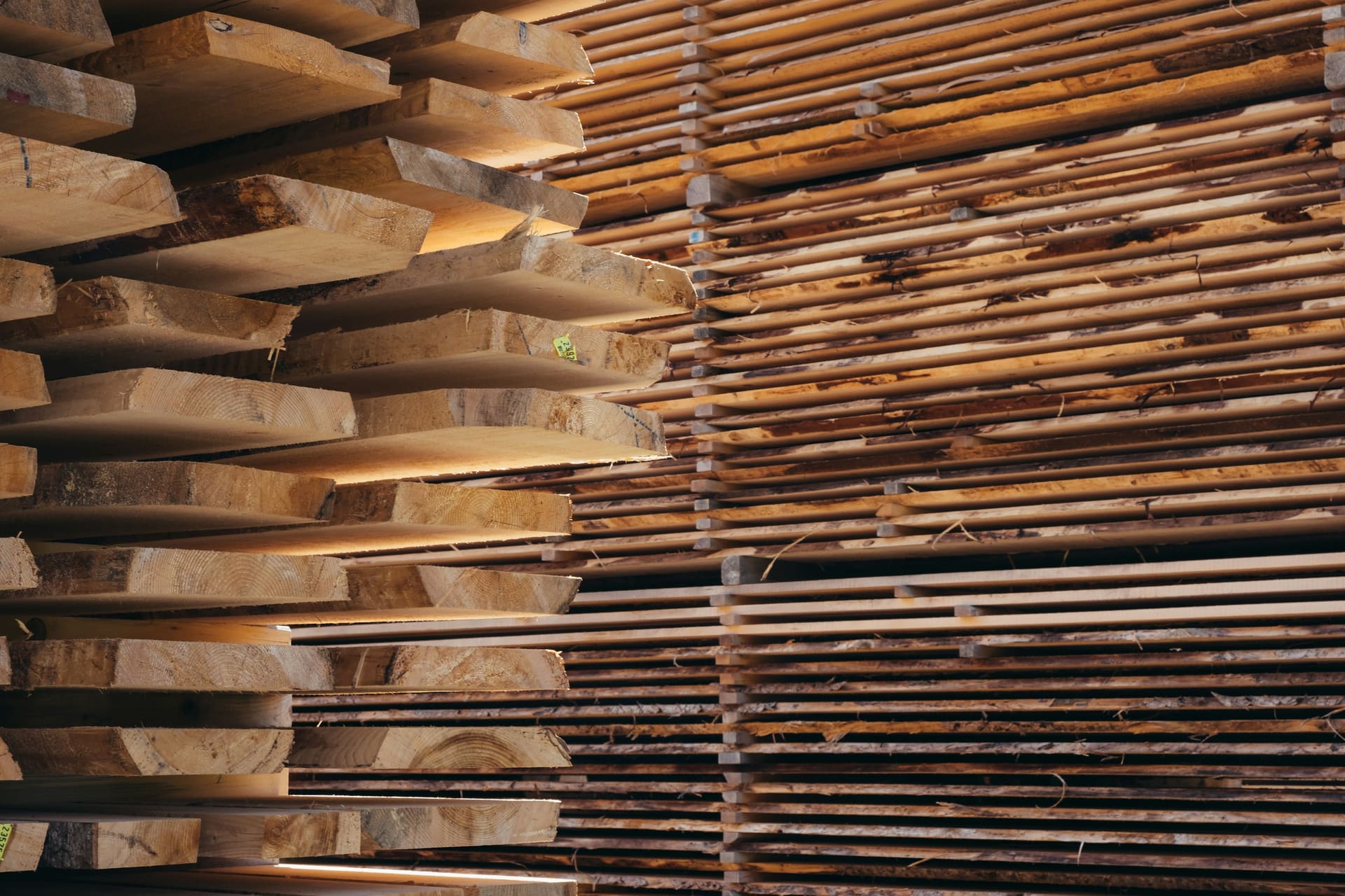 Stacked lengths of sawn timber arranged in a covered storage area, used as visual context for wholesale timber supply.