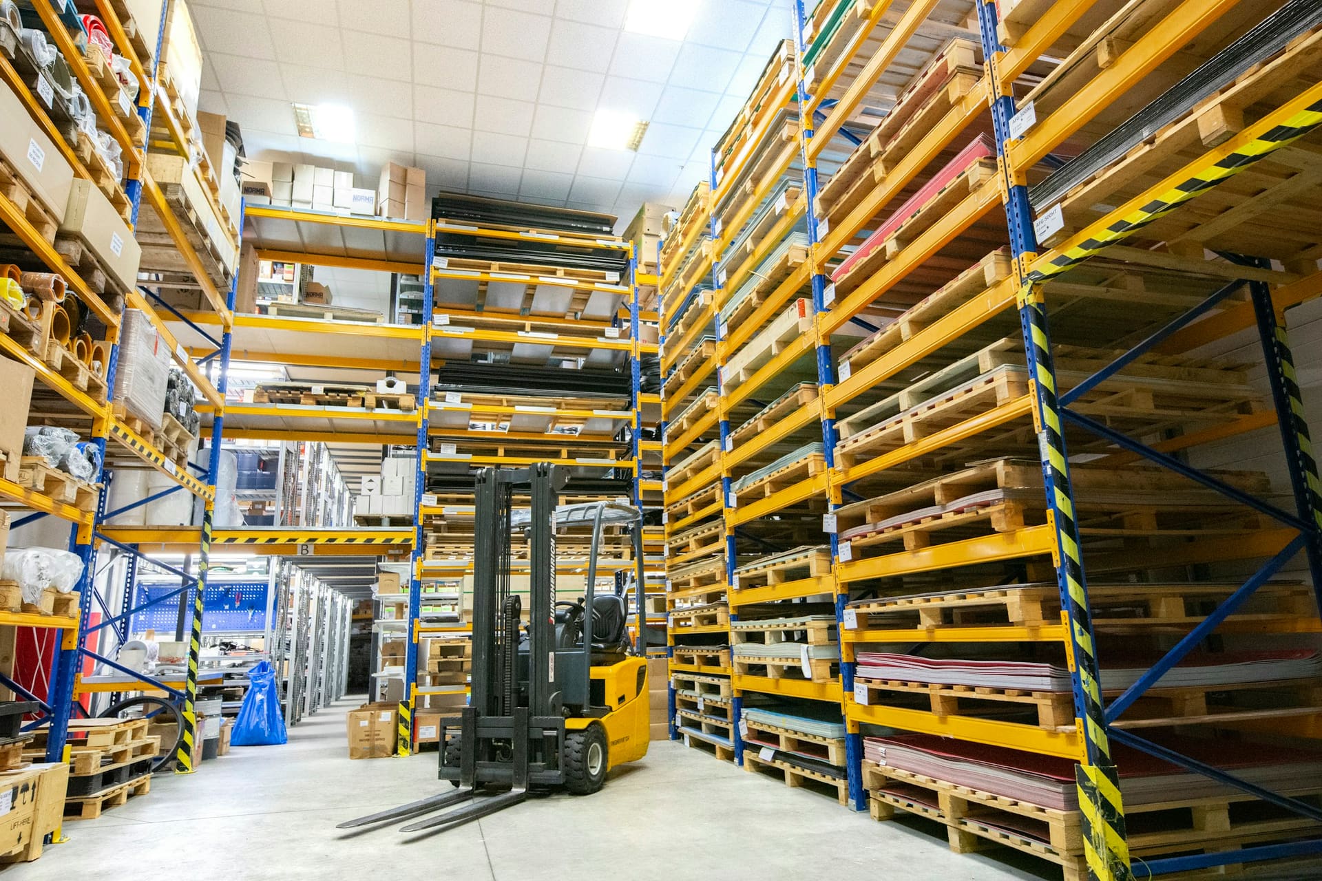 Building material pallets prepared in a warehouse, used as fulfilment stage context imagery.