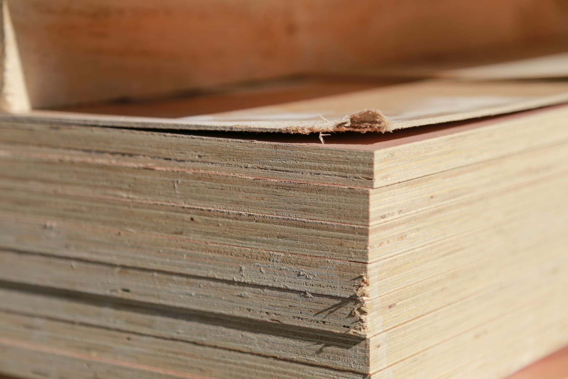 Stacked plywood sheets showing layered edges, used as sheet material specification context imagery.