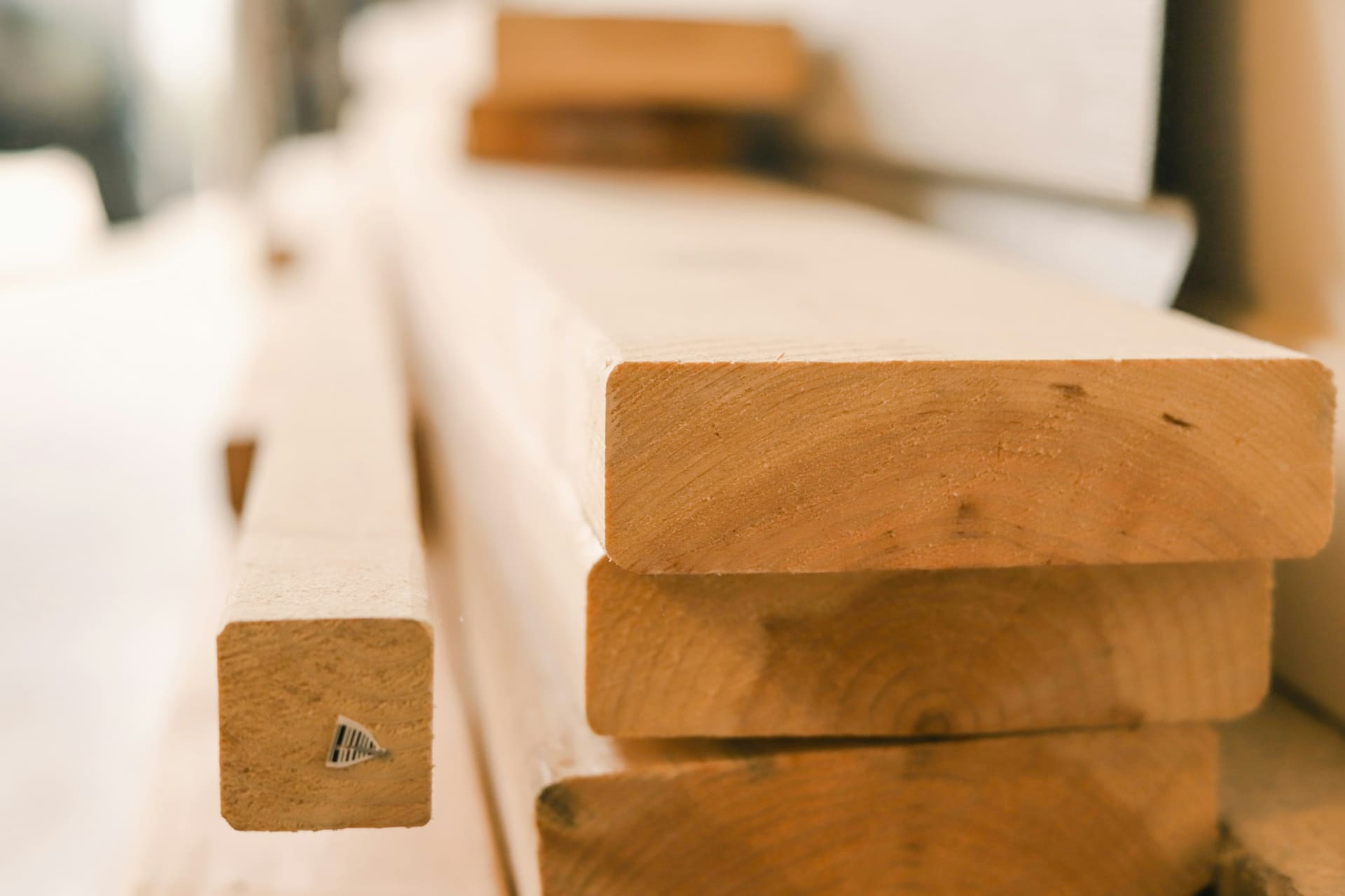 Heavy wooden beams stored horizontally, used as context imagery for structural and general building timber.