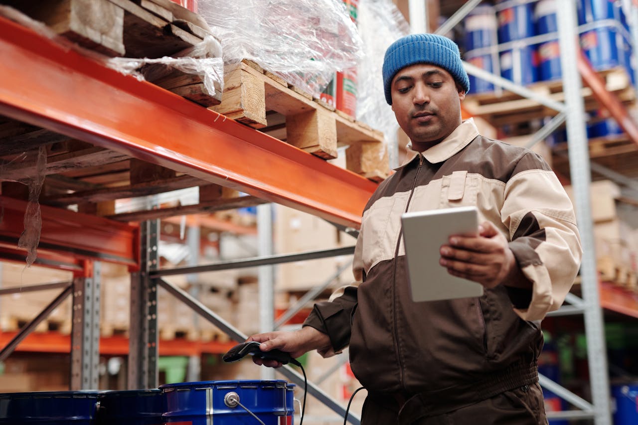gallery-1 A warehouse employee scans items using a tablet, ensuring inventory accuracy.